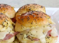 two ham and cheese sliders on a white plate with black pepper sprinkles