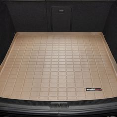 the trunk area of a car with its cargo compartment open and it's floor mat folded down