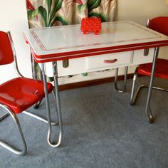 two red chairs and a white table in a room