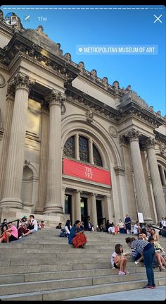 people are sitting on the steps in front of an art museum