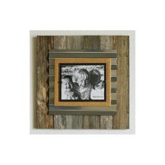 an old photo frame hanging on a wooden wall