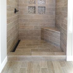 a walk in shower sitting inside of a bathroom next to a window and wooden floors