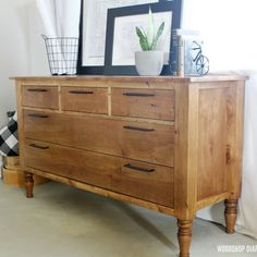 a wooden dresser sitting next to a window