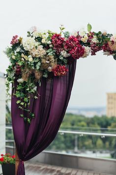 an outdoor ceremony with purple drapes and flowers