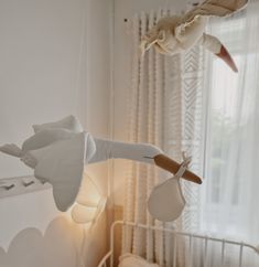 a baby crib with a stuffed animal hanging from it's side