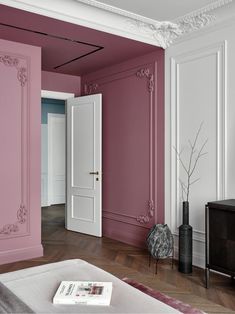 an empty room with pink walls and white trim on the door, in front of a tv