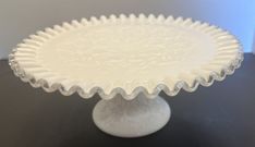 a white cake plate sitting on top of a table