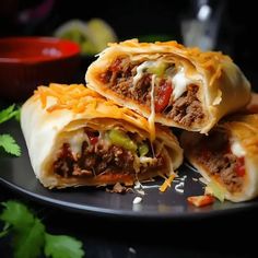 three burritos cut in half on a black plate