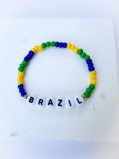 a beaded bracelet with the word brazil written in white and yellow beads on it