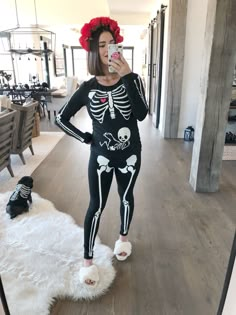 a woman in skeleton costume taking a selfie