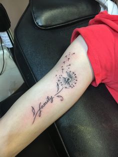 a woman's arm with a dandelion tattoo that says happy on it