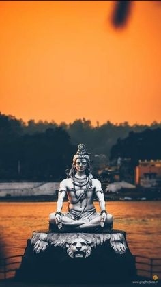 a statue sitting on top of a body of water