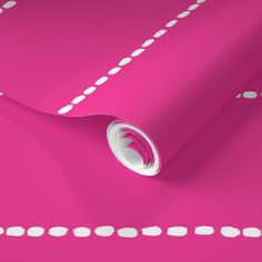 a roll of pink paper with white dots on the edge and an oval hole in the middle