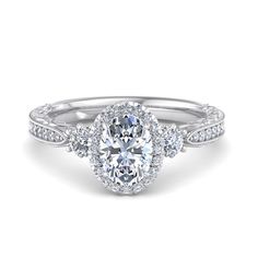 an oval cut engagement ring with three halos on the band and side stones in white gold