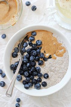 a bowl filled with oatmeal and blueberries on top of a table