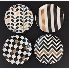 four plates with black and white designs on them