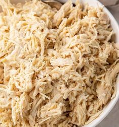 shredded chicken in a white bowl on a table