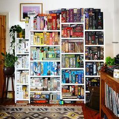 a bookshelf filled with lots of books in a living room