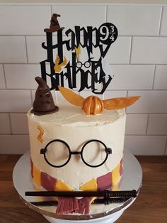 a harry potter themed birthday cake with glasses and hogwart's hat on top