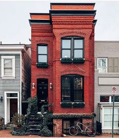 a bicycle is parked in front of a red brick house