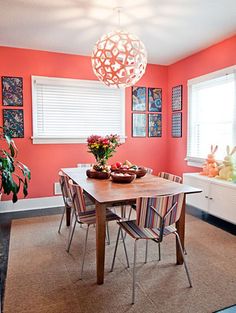 a dining room table with chairs and a bowl of fruit on top of the table