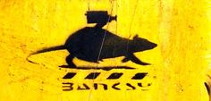 a yellow and black sign with a rat on it