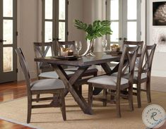 a dining room table with chairs and a vase on it's centerpiece, in front of a doorway