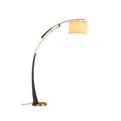 a floor lamp with a beige shade on the side and a black base that has a gold trim around it