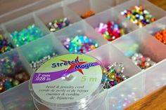 a box filled with lots of different colored beads and sprinkles on top of a wooden table