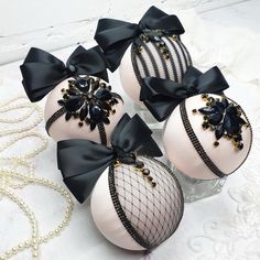 four white balls with black bows on them