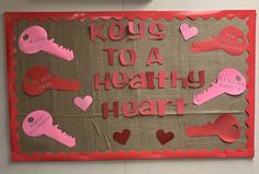 a bulletin board that says keys to a healthy heart with pink and red cut outs