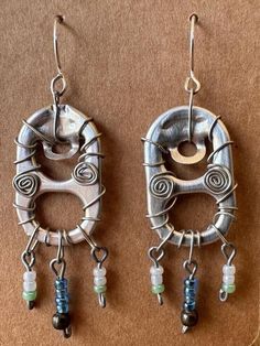 two silver earrings with beads hanging from them