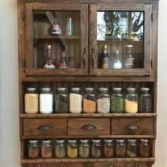 a wooden shelf with jars and spices on it