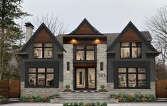 this is an artist's rendering of a two story house with stone and wood accents