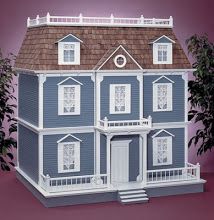 a blue and white doll house on a pink background