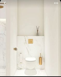 a bathroom with marble walls and flooring, including a toilet in the corner that has gold accents on it