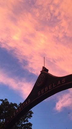 the sky is pink and blue with some clouds in it, as seen from below