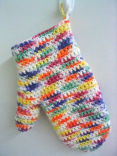 an oven mitt hanging from a hook on a white wall with multicolored stripes