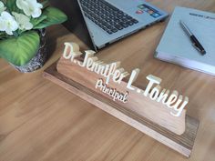 a wooden sign that says dr douglas l honey on top of a desk next to a laptop