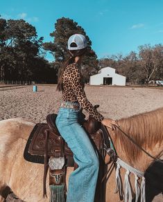 a woman riding on the back of a brown horse