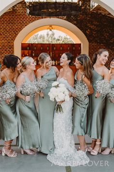 a group of women standing next to each other in front of a building with flowers