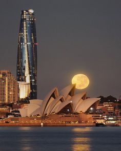 the full moon is setting over sydney, australia