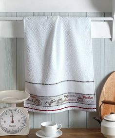 a white towel hanging on the side of a kitchen counter next to a tea pot