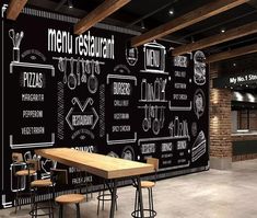 a restaurant wall with chalkboard menus on it and stools around the table