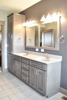 a large bathroom with double sinks and two mirrors on the wall above them is shown