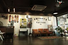 the inside of a tattoo parlor with lots of chairs and pictures on the wall behind them