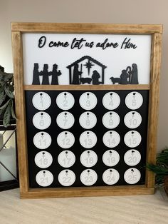 a black and white christmas calendar with nativity scene in the middle, surrounded by evergreen branches