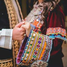 two people are holding hands and wearing colorful bracelets on their wristes while standing next to each other