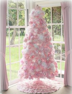 a pink christmas tree in front of a window