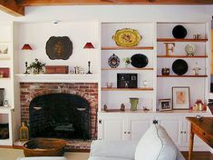 a living room filled with furniture and a fire place next to a wall mounted tv